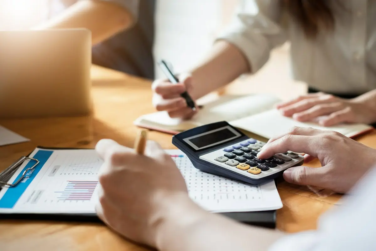 mężczyzna z kalkulatorem przeglądający dokumenty finansowe
